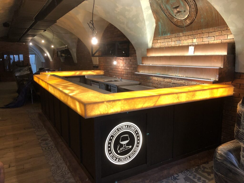 POdsvietený kameň Orange Onyx použitý v barovom pulte