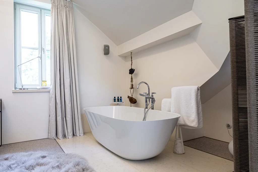 Moderná kúpelňa s voľne stojacou vaňou a kamennou dlažbou